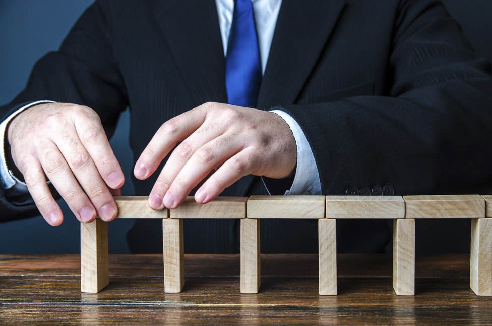 a business owner using wooden blocks to create a bridge